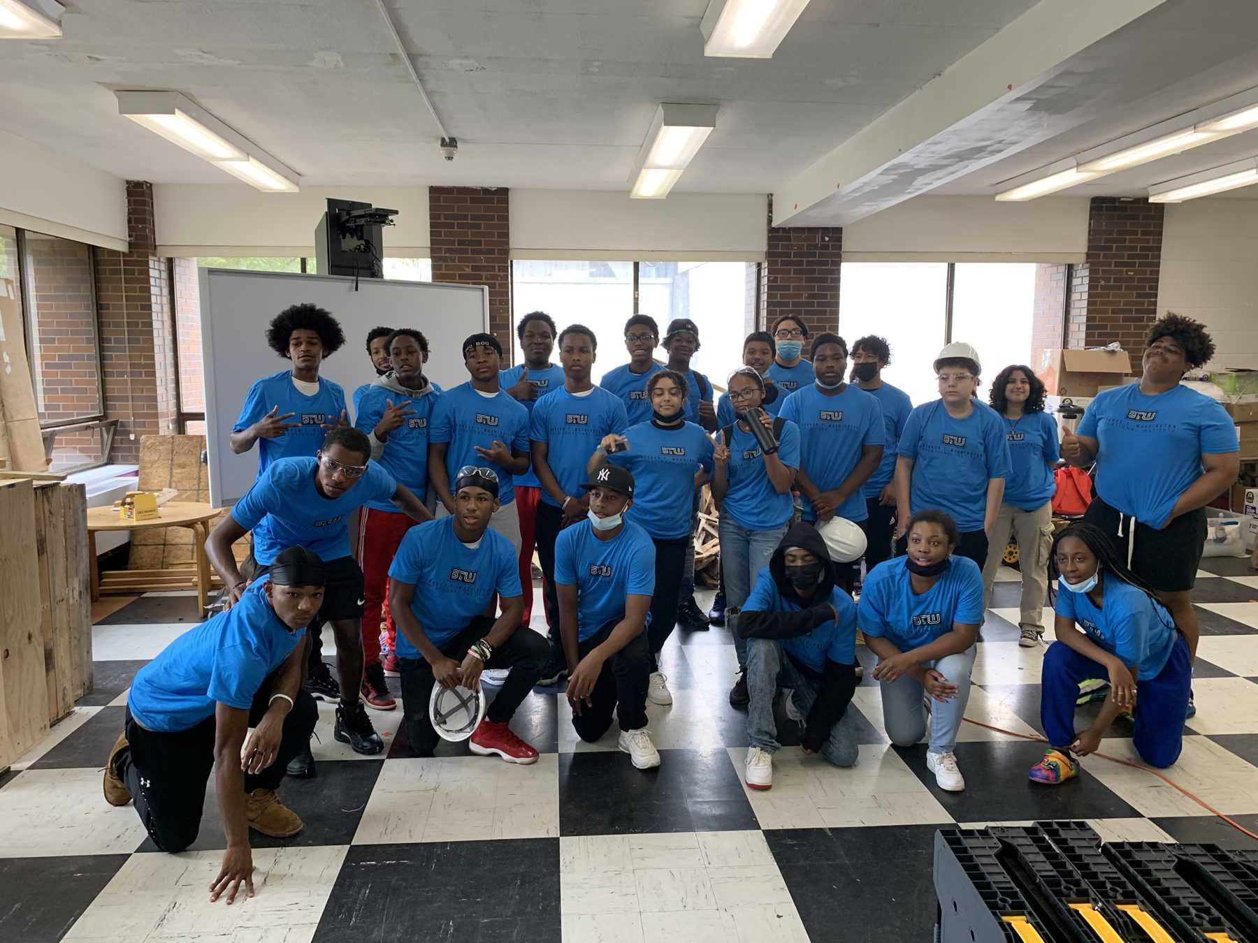 A BTW cohort in matching blue shirts posing for a group photo