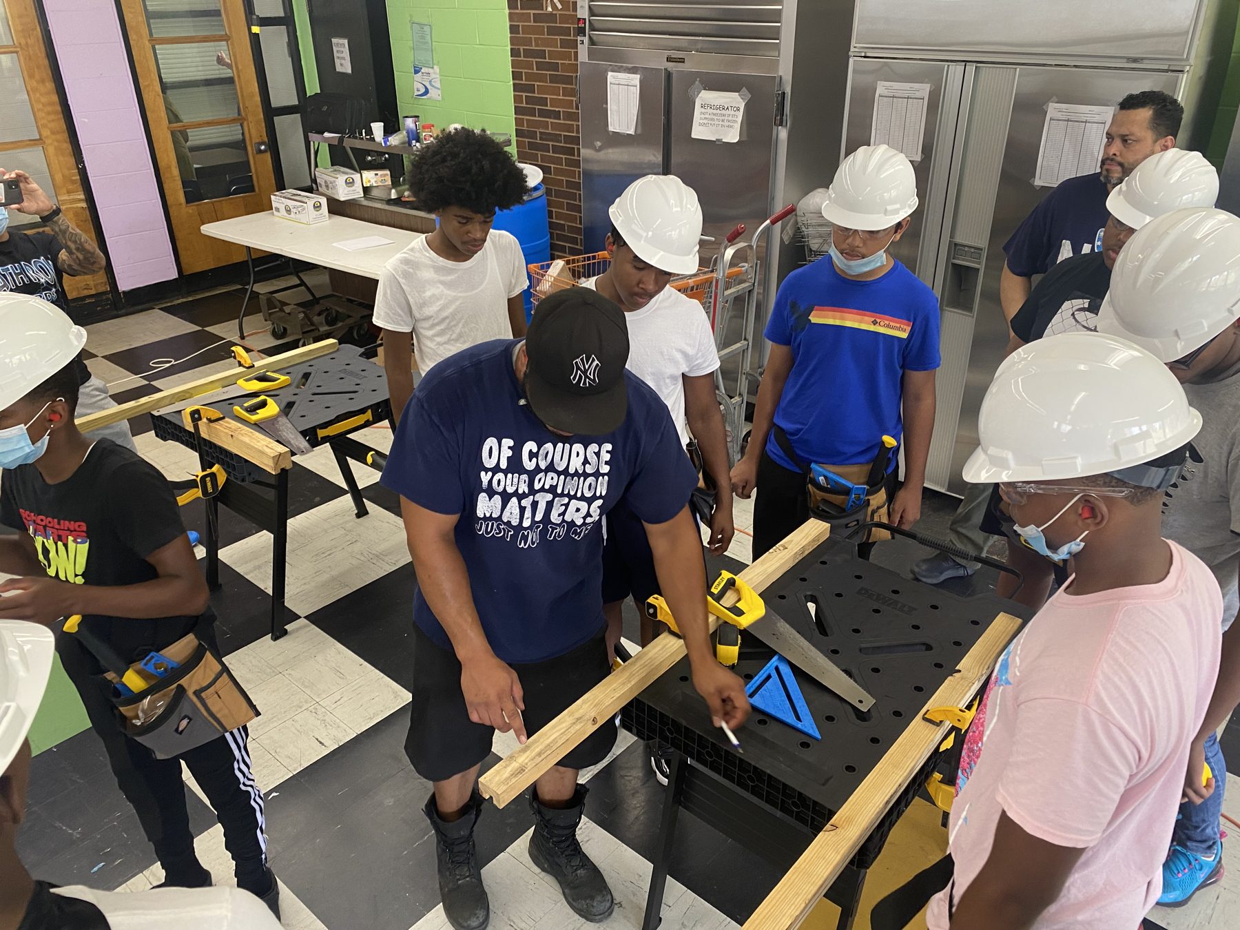 A team of BTW trainees measuring and marking lumber together