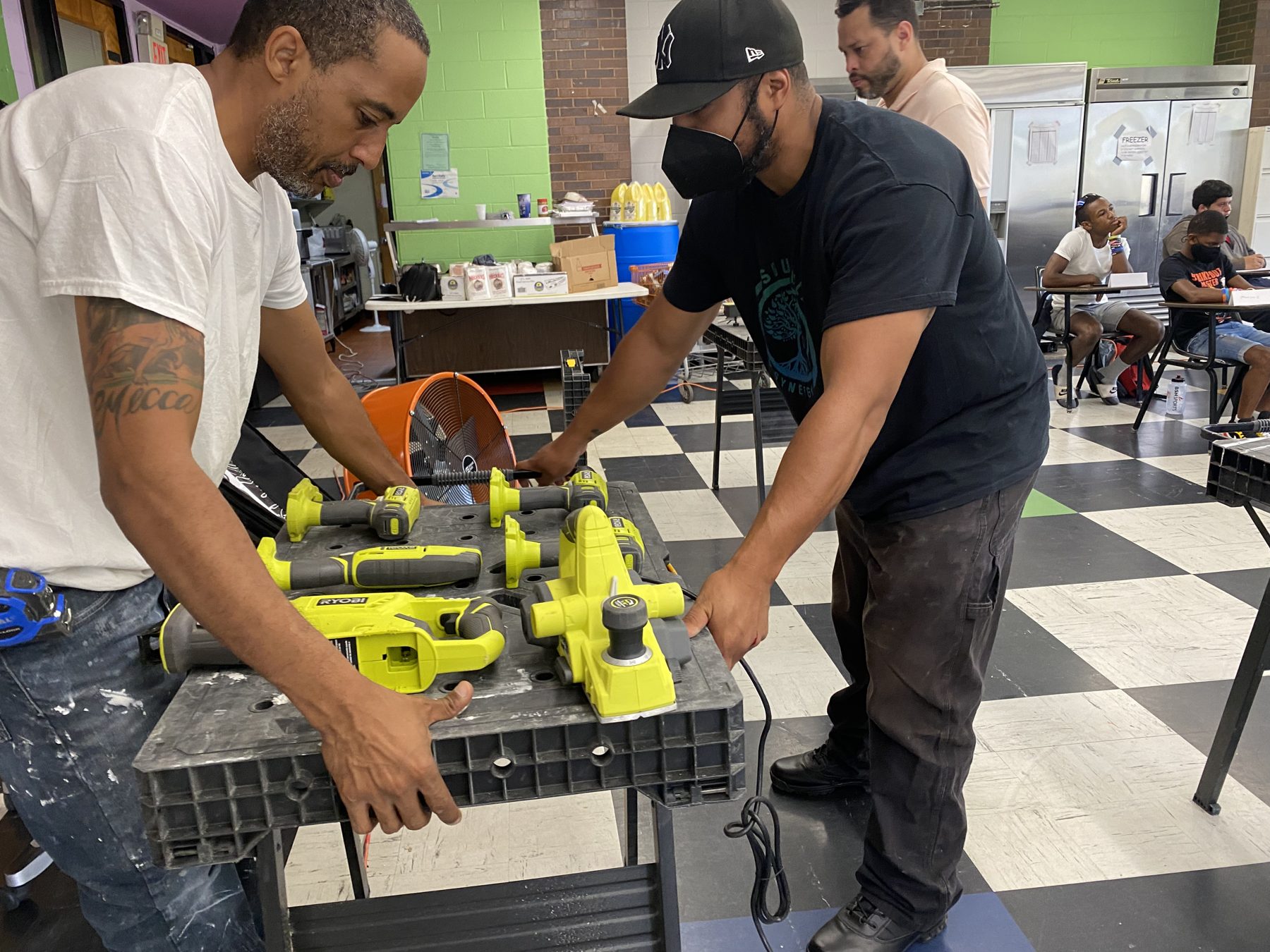 Instructor demonstrating a cordless power tool to a BTW student