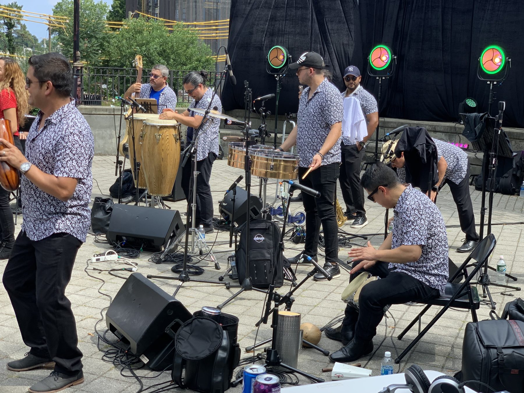 Community event stage crew setting up instruments and sound